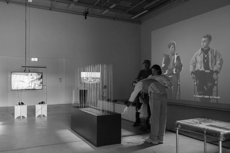 Ausstellung im Aktionsraum. Auf die rechte Wand wird ein Film projiziert. Es steht ein Exponat mitten im Raum. © David Jäggi.