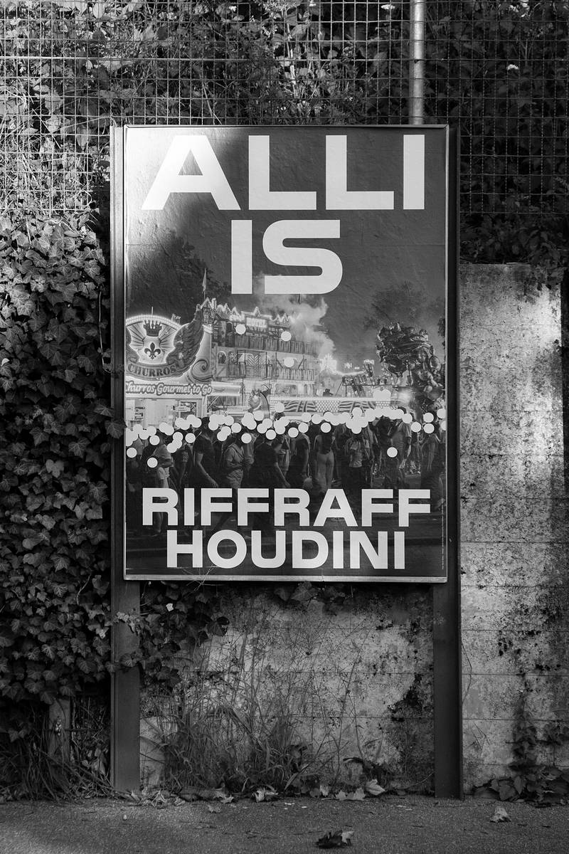 riffraff2.jpg Plakat der Kampagne «Alli is Riffraff/Houdini» in der Stadt vor einer Gartenmauer. Auf dem Plakat sind viele Menschen auf einem Jahrmarkt zu sehen, alle Gesichter sind kleine gelbe Punkte. Gelbe Schrift: «Alli is Riffraff/Houdini».