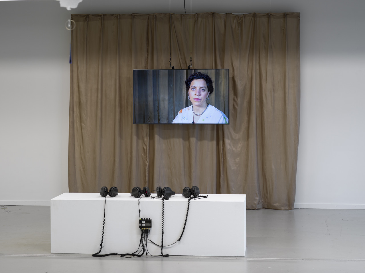 INSIDE OUTSIDE ARTIST MOTHER ECHO CHAMBER 2024 Videoinstallation, 15 Minuten, Bildschirm vor goldenem Vorhang 