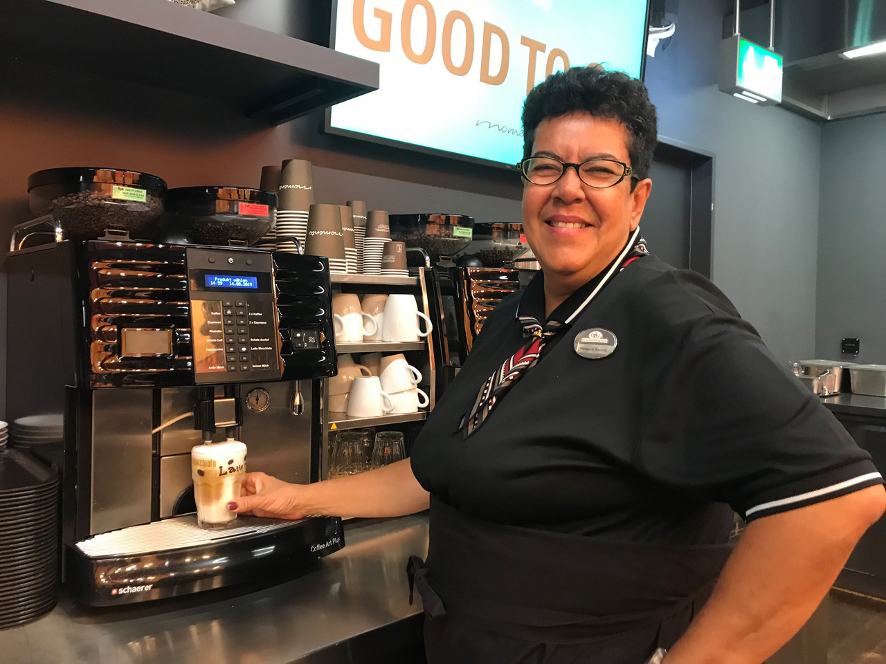 [Translate to English:] Frau an Kaffeemaschine